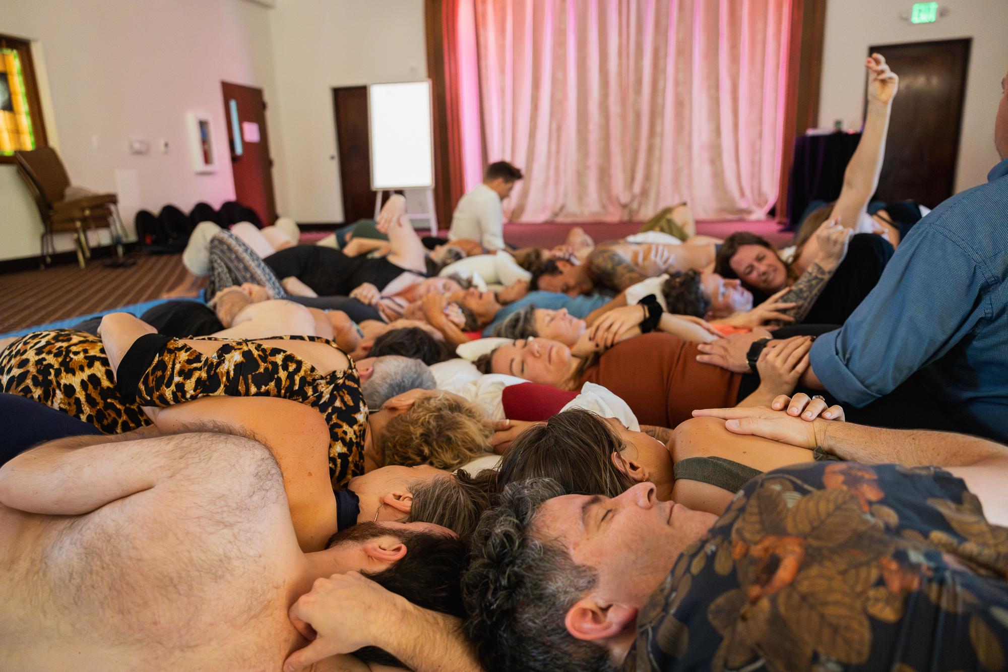Participants lying in a circle during somatic practice, an intimate moment of shared presence
