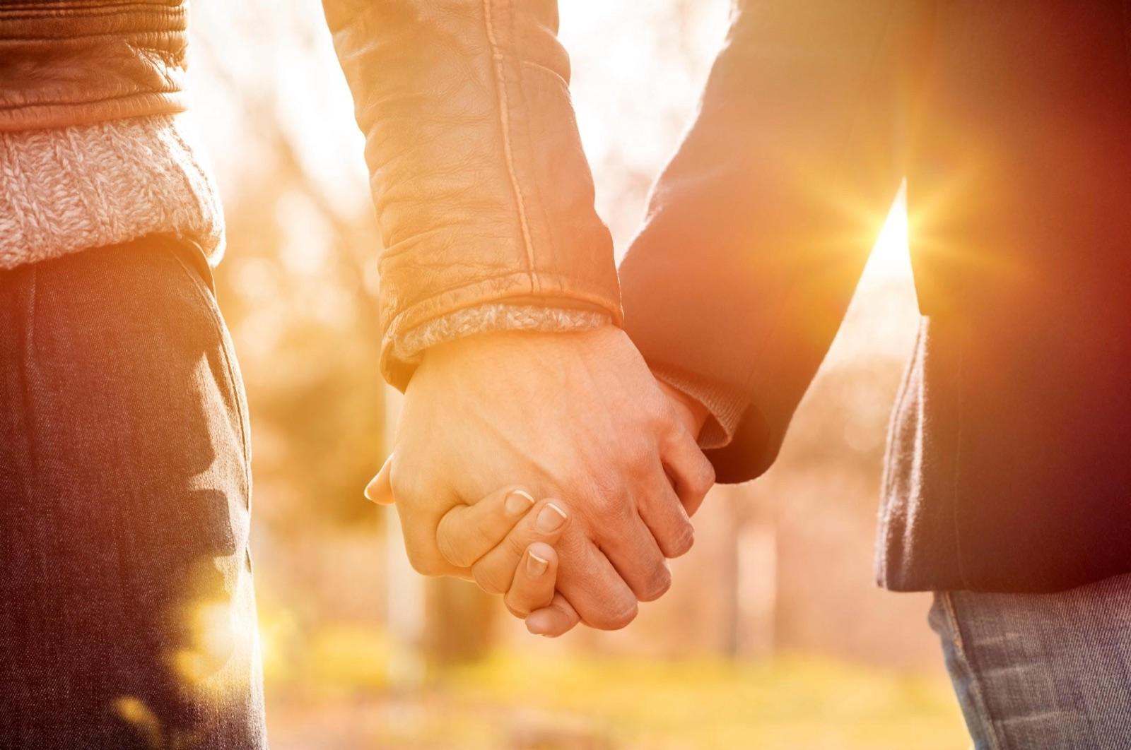 A couple holding hands in warm light
